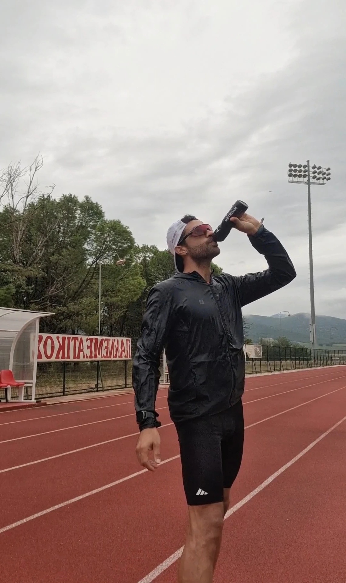 Δρομέας ενυδατώνεται στο στάδιο μετά από έντονη προπόνηση.